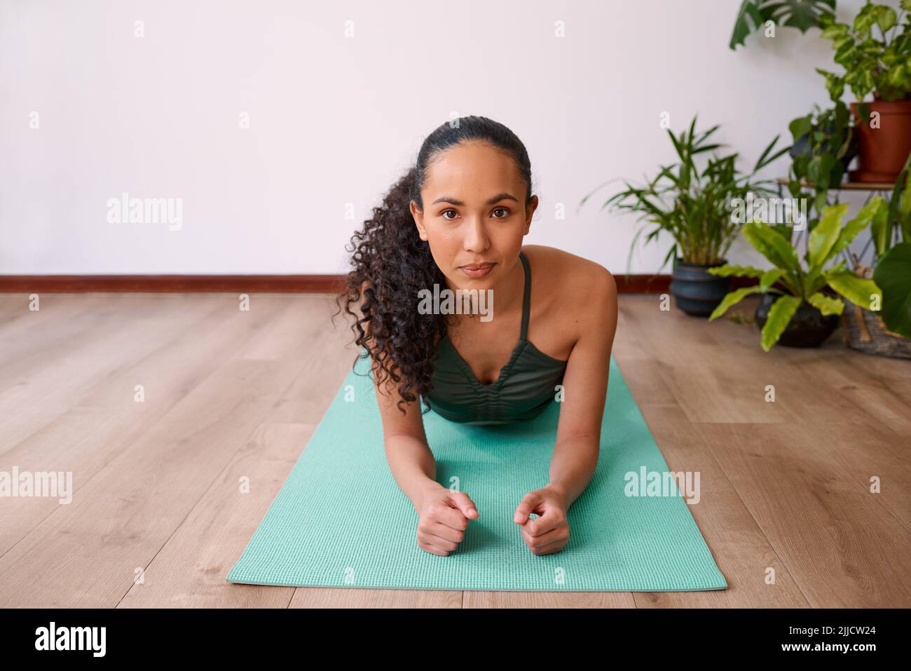 Eine multiethnische Frau blickt direkt nach vorne, während sie sich vom Unterarm nach oben ruht Stockfoto