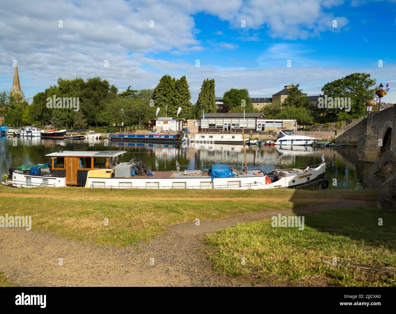 Wir stehen am Südufer der Themse bei Abingdon, direkt an der mittelalterlichen Brücke von Abingdpn. Auf der anderen Flussseite dominiert der Blick Saint Hele Stockfoto