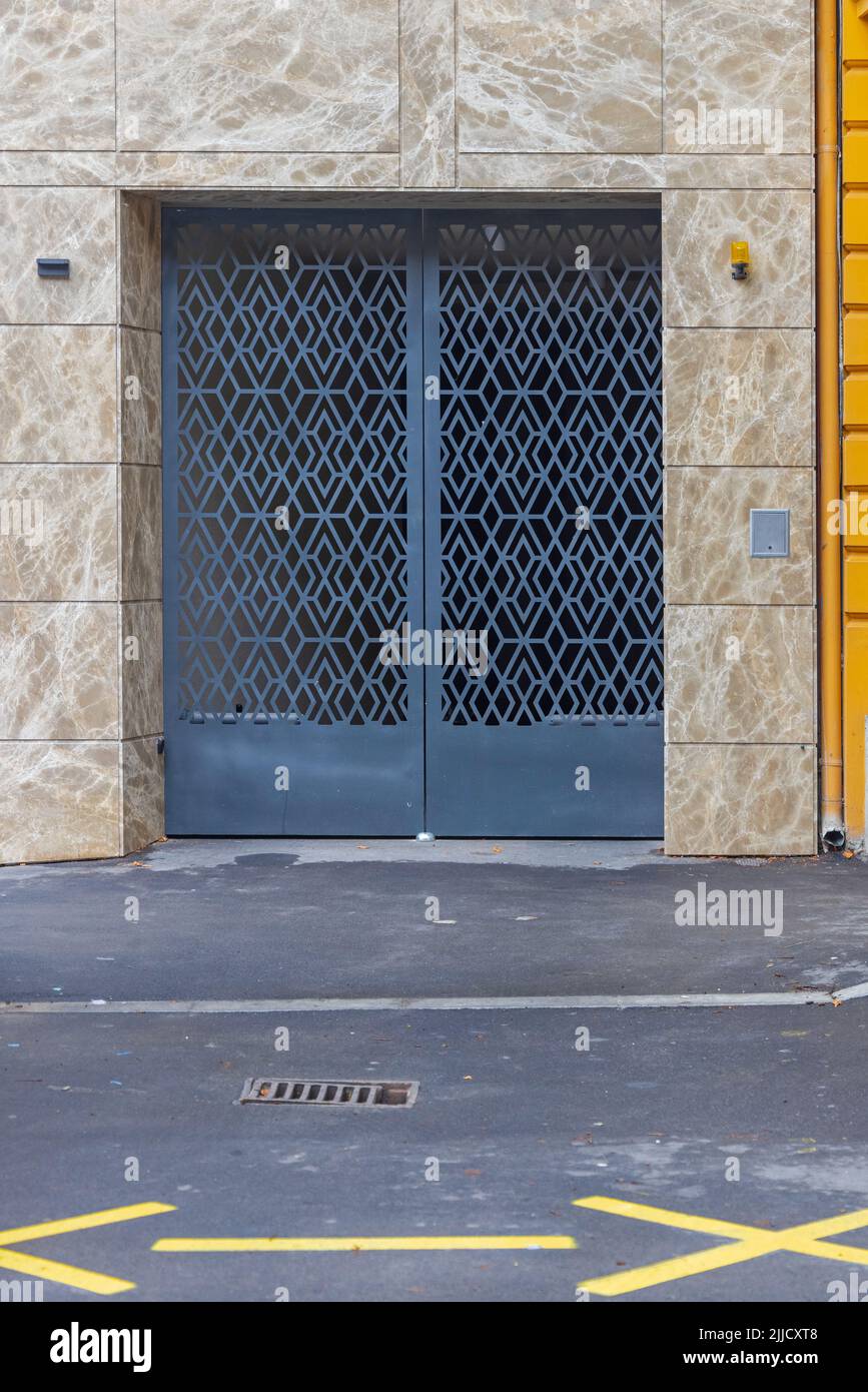 Geschlossene Garagentüren am Gebäude mit Marmorsteinfliesen Stockfoto