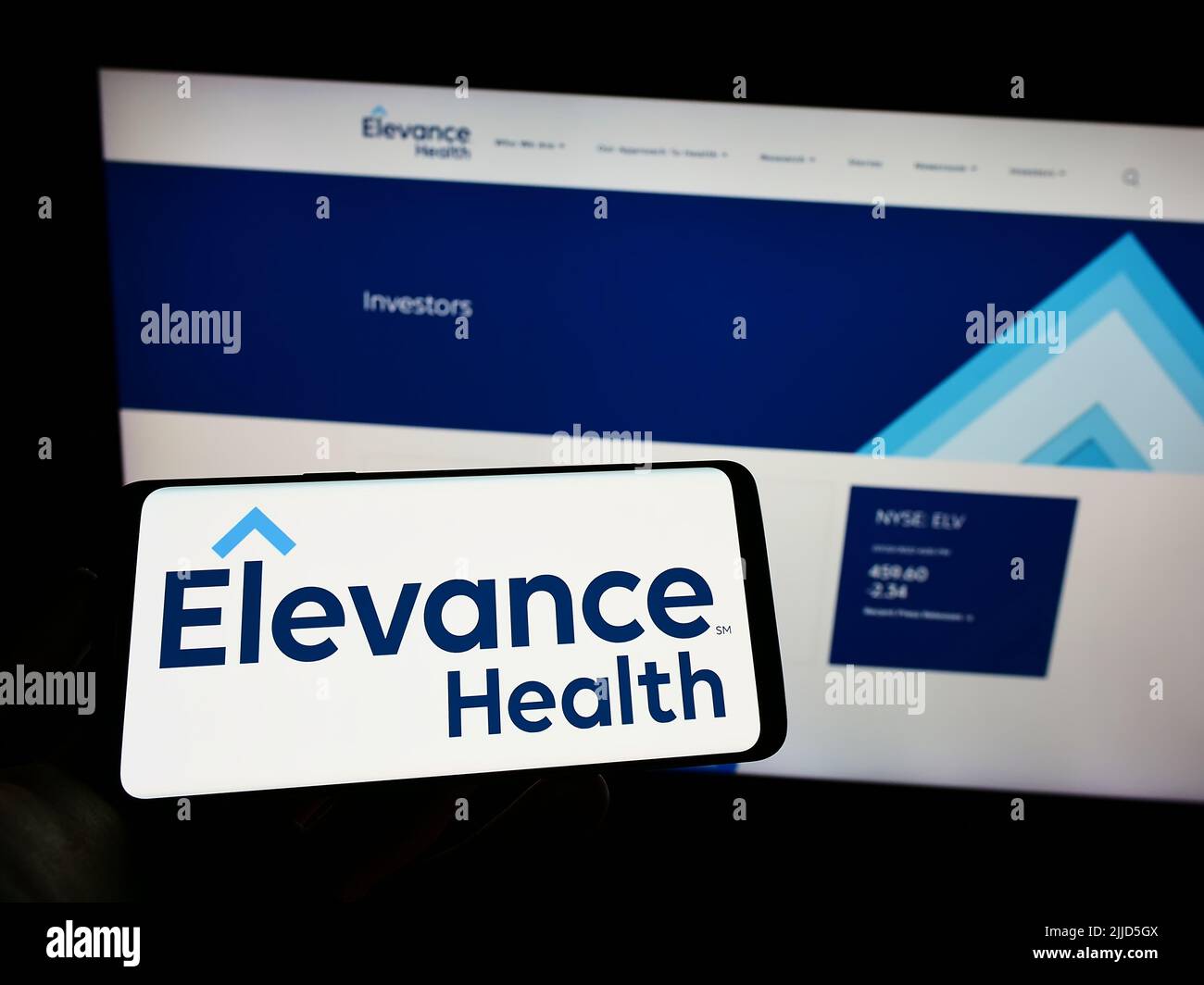 Person mit Mobiltelefon und Logo der US-Versicherungsgesellschaft Elevance Health Inc. Auf dem Bildschirm vor der Business-Webseite. Konzentrieren Sie sich auf die Telefonanzeige. Stockfoto