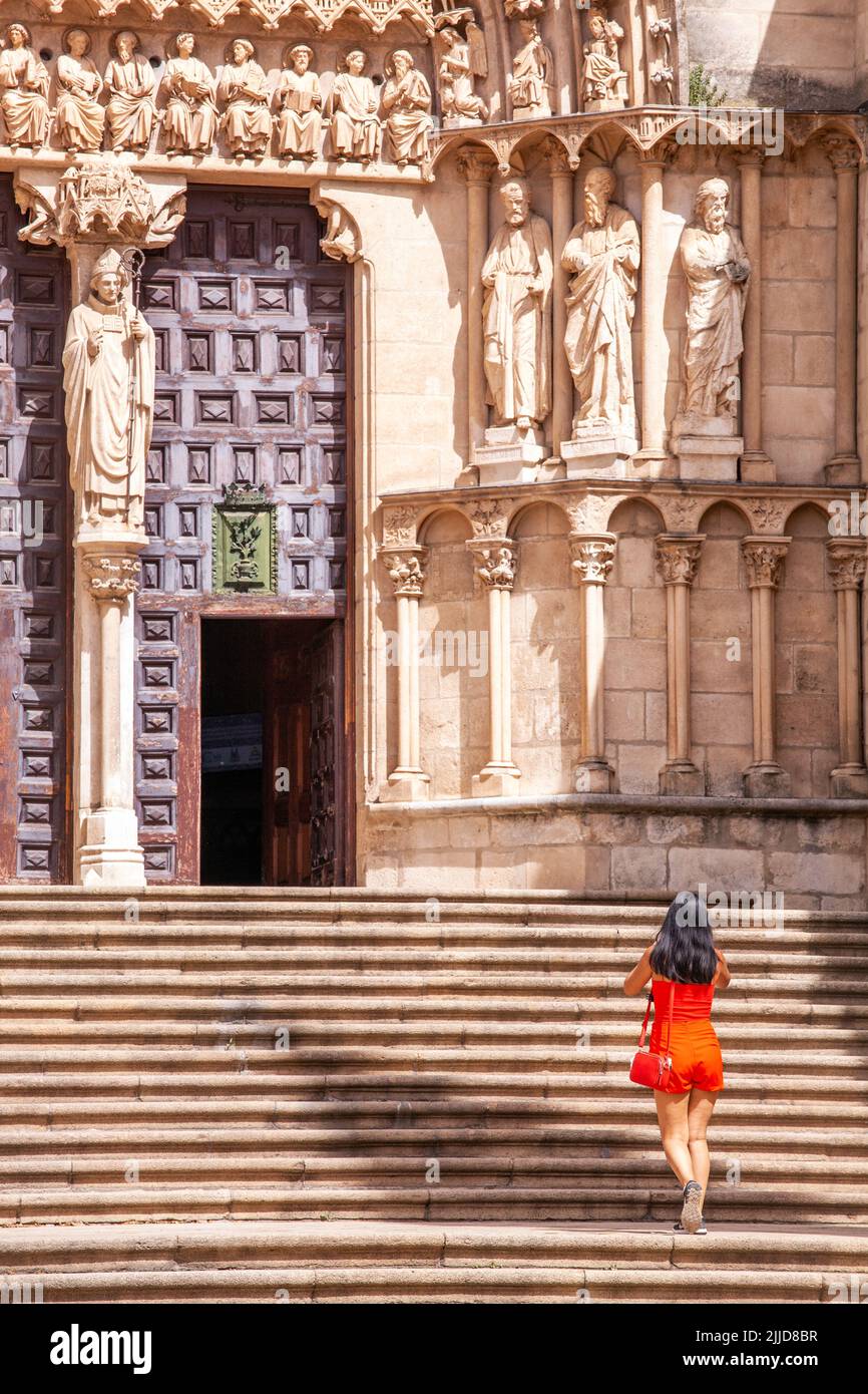 Frau in einem roten Kleid auf den Stufen zur Kathedrale der Jungfrau Maria in der spanischen Stadt Burgos Spanien Stockfoto