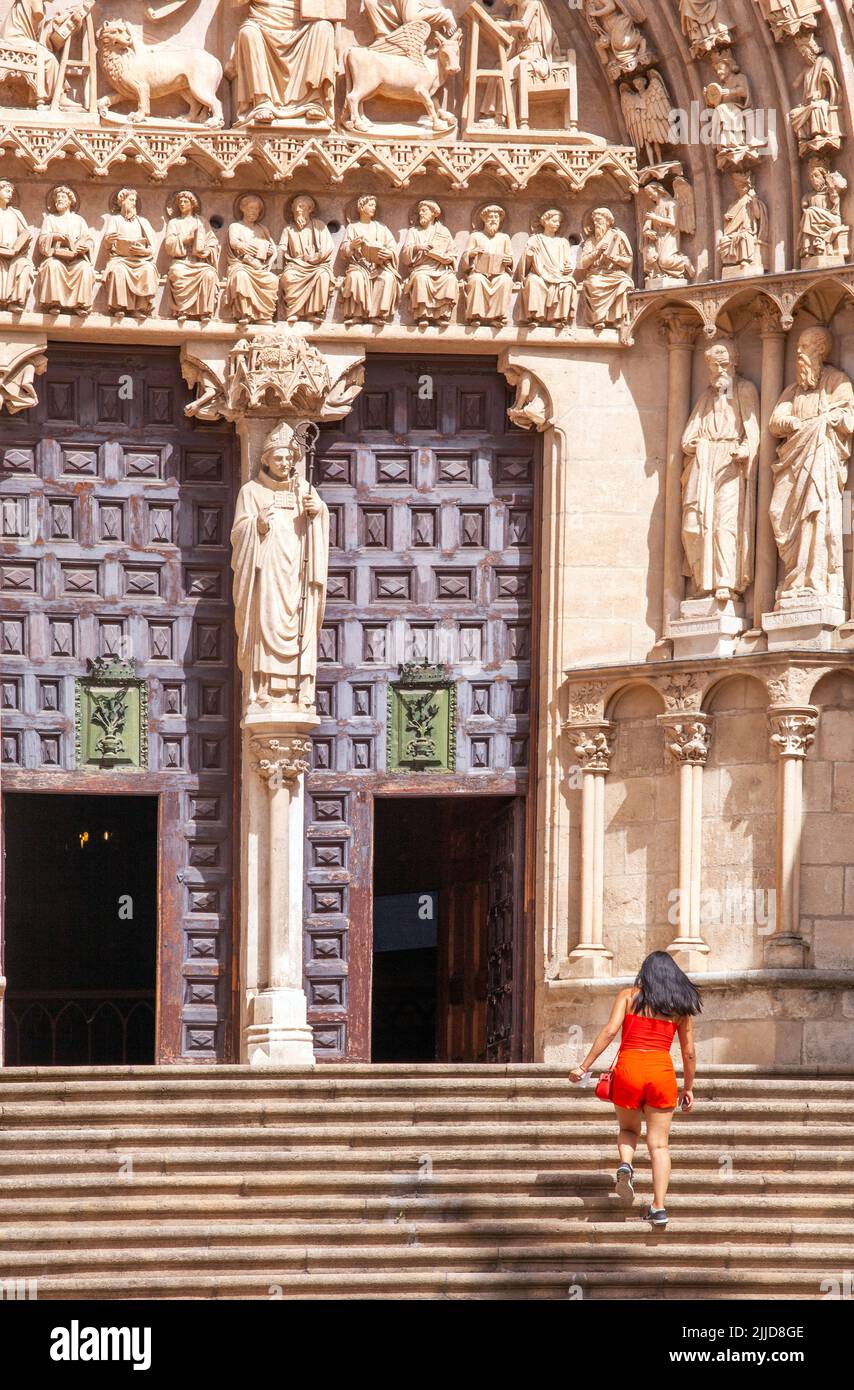Frau in einem roten Kleid auf den Stufen zur Kathedrale der Jungfrau Maria in der spanischen Stadt Burgos Spanien Stockfoto