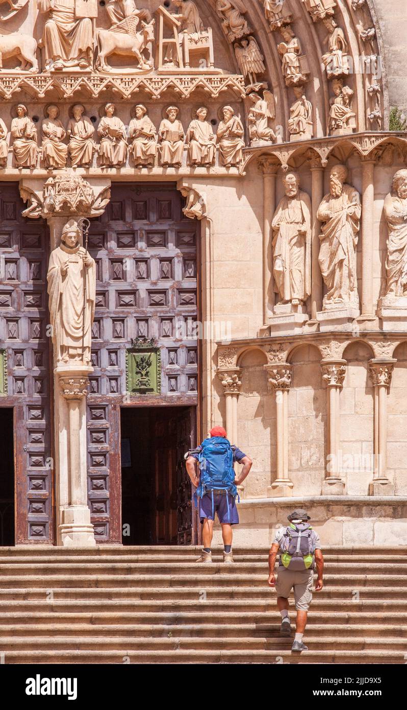 Zwei Pilger, die den Camino de Santiago auf den Stufen zur Kathedrale der Heiligen Jungfrau Maria in der spanischen Stadt Burgos, Spanien, besuchen Stockfoto