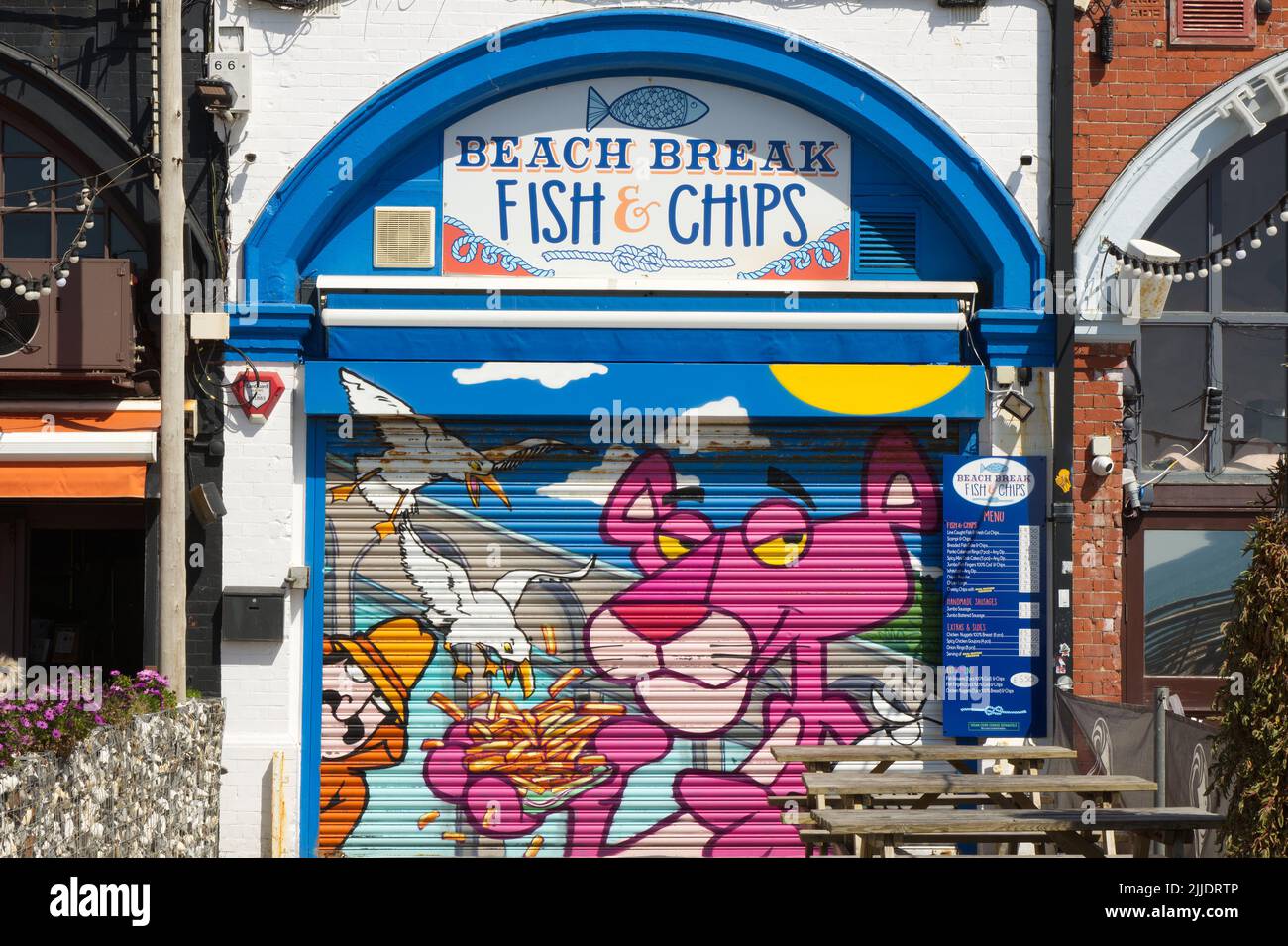 Kunstwerke von Zeichentrickfiguren auf geschlossenen Fensterläden des Fish and Chip-Shops an der Strandpromenade von Brighton Beach, East Sussex, England Stockfoto