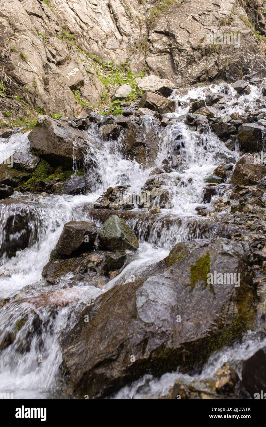 Der Gebirgsfluss fließt schnell aus der Nähe über Felsen. Stockfoto