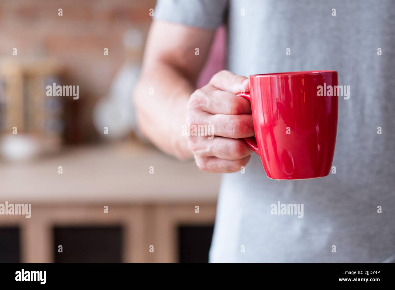 Morgen warmes Getränk Frühstück Mann halten roten Becher Stockfoto