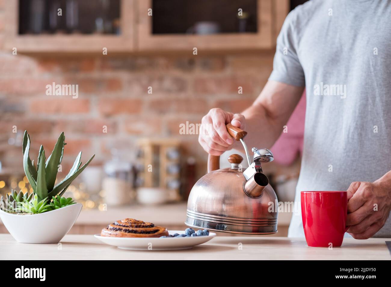 Traditionelles Frühstück Essen Wasserkocher Tee rote Tasse Mann Stockfoto