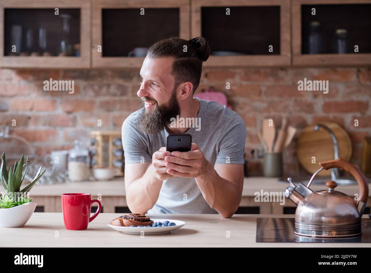 Leerlauf Freizeitsucht Mann Telefon Küche Frühstück Stockfoto