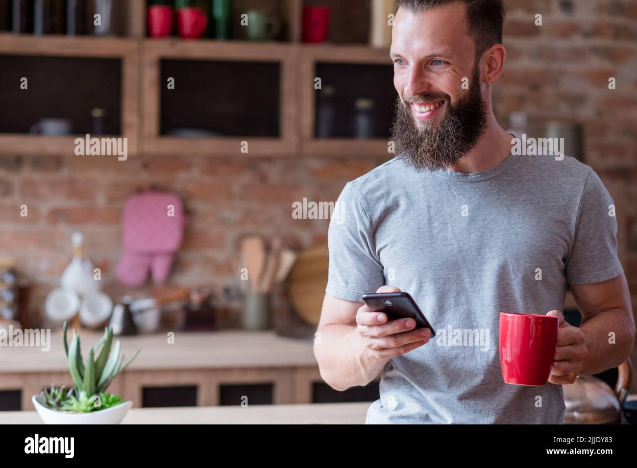 Lifestyle Gerät sucht Mann Küche Telefon Tasse Stockfoto