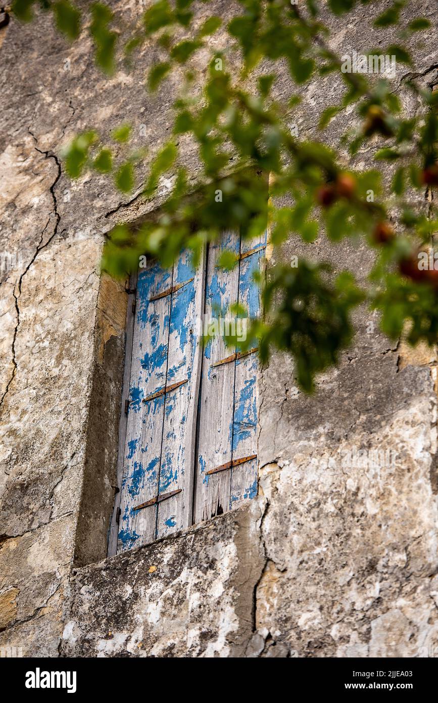 Blätternde blaue Farbe auf verzweifelten hölzernen Fensterläden auf alten typisch griechischen rustikalen oder ländlichen Landhäusern auf der Insel kreta in griechenland, schäbig chic. Stockfoto