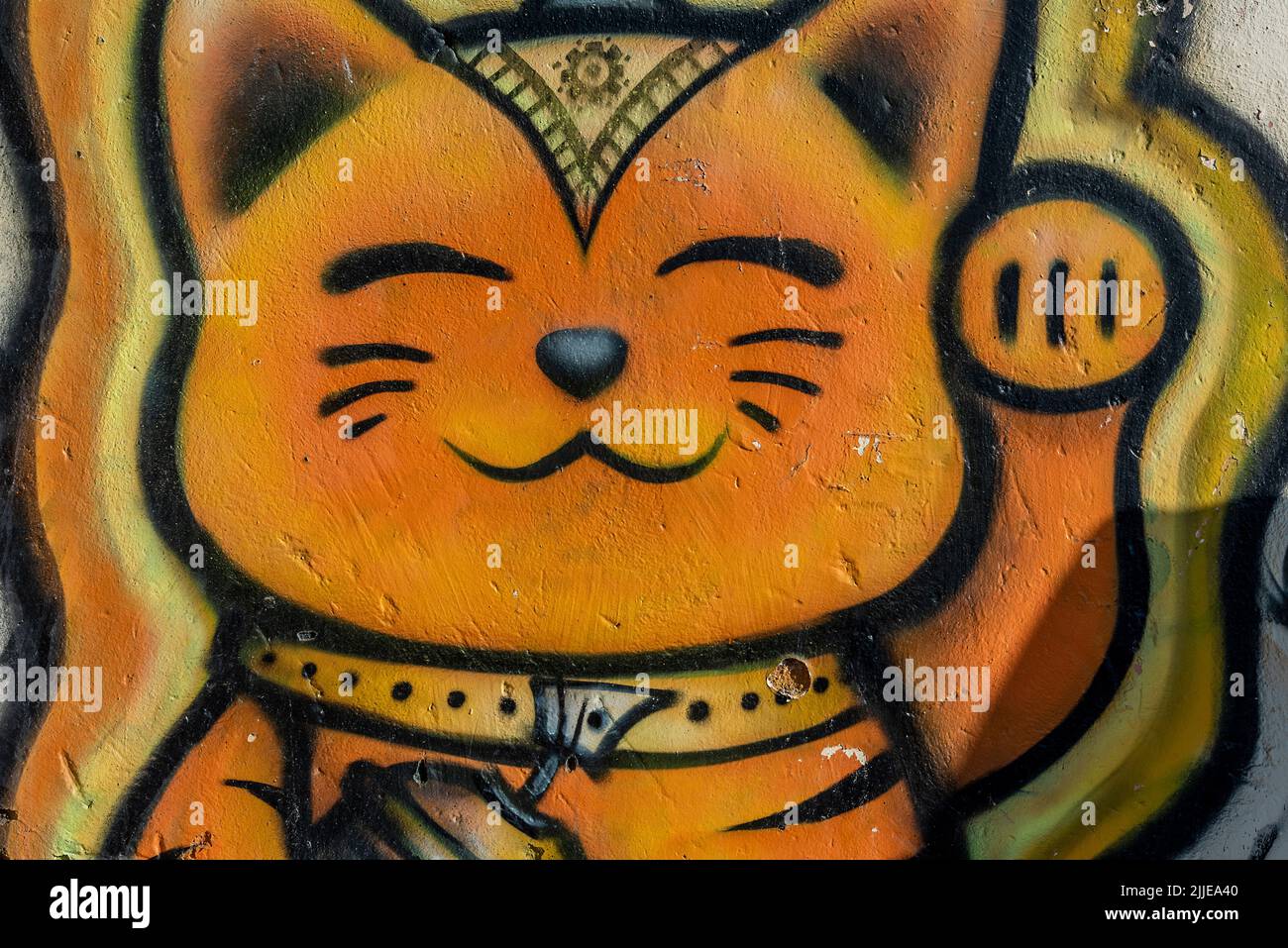 chinesische Katze Katze Katze Wandmalerei, komödiantisches Katze. Katze winken, Komödie Katze, humorvolle Katze, lächelnde Katze, Cartoon-Gemälde von Katze, orange gefärbte Katze. Stockfoto