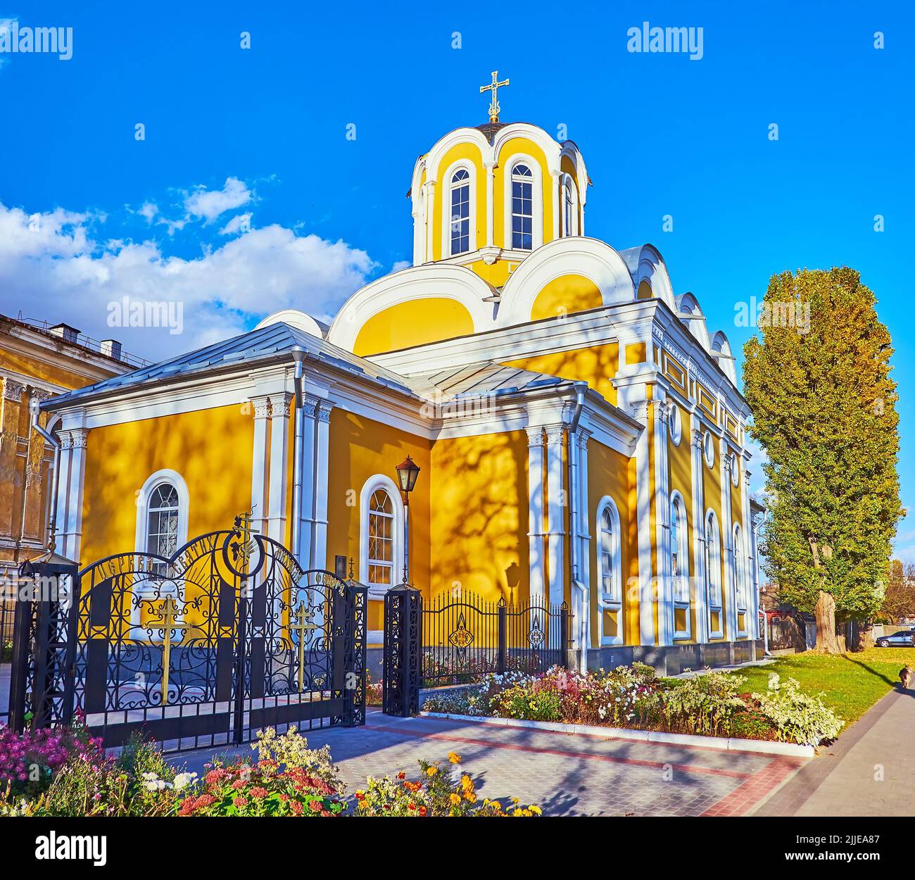 Außenansicht der gelben Auferstehungskirche St. Michael und St. Fedor, umgeben von Blumenbeeten, Tschernihiw, Ukraine Stockfoto