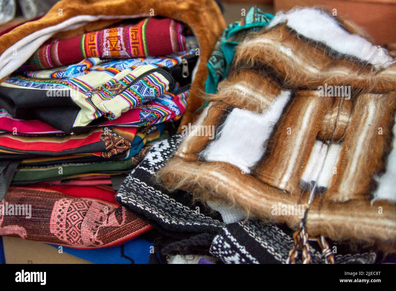 Stapel von bunten Gaucho Ponchos, Taschen und rustikal gestreiften Decke handgefertigt in argentinien. Serape Design. Traditionelle Kleidung im Norden argentiniens Stockfoto