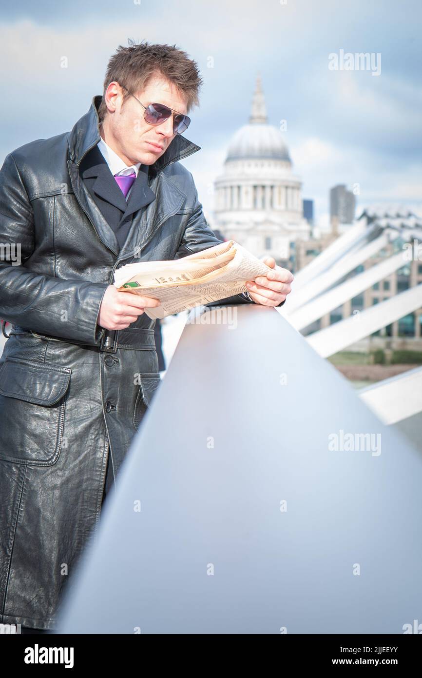 Undercover-Agent; Intel wird überprüft. Ein Spion in einer verdeckten Operation auf der Millennium Bridge, London; aus einer Reihe von Bildern mit dem gleichen Charakter. Stockfoto