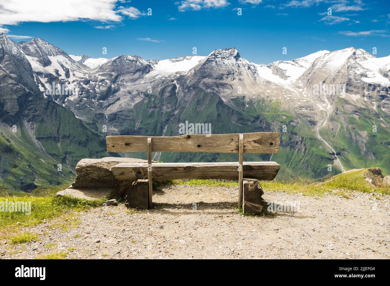 Hohe Tauern. Holzbank mit dramatischer Aussicht auf die Berge im Sommer. Zentralostalpen in Österreich. Stockfoto