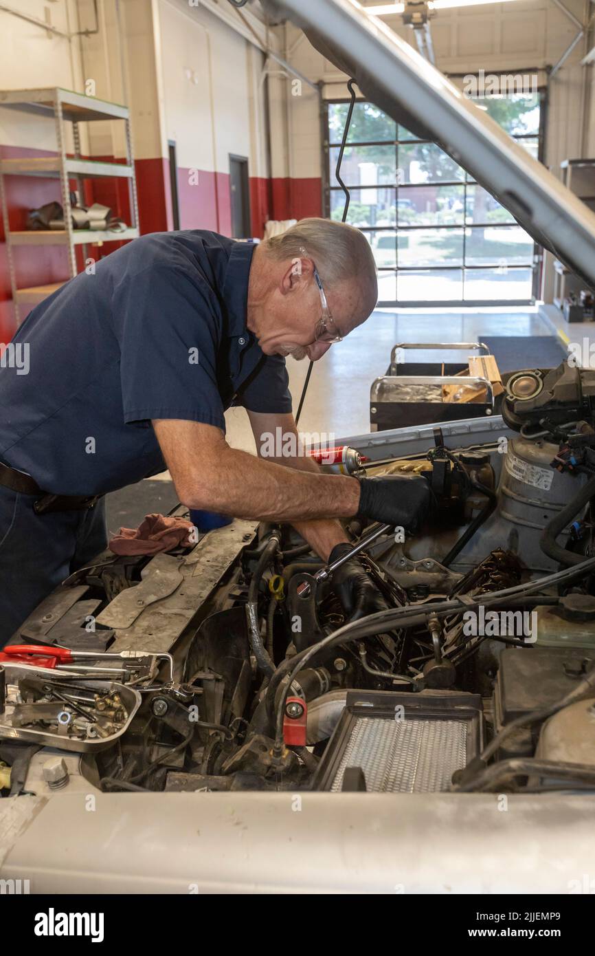 Aurora, Colorado - Russell Bacon behebt das Ölleck eines Autos durch die Hände des Carbenters. Die gemeinnützige Organisation repariert Fahrzeuge, die alleinerziehenden Müttern gehören, bei der Reduzierung Stockfoto