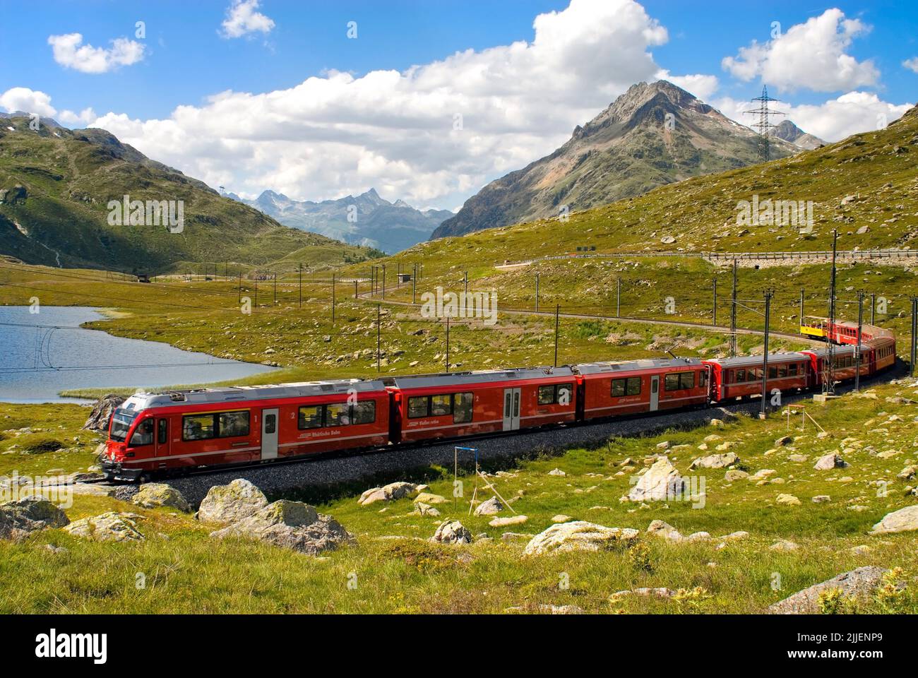 Zug des Rhätischen Zuges am Lago Bianco am Bernina Pass, Schweizer Alpen, Schweiz Stockfoto