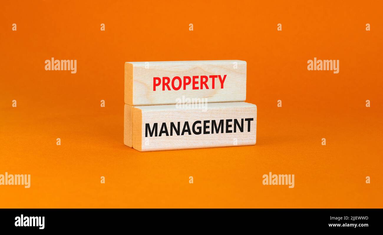 Symbol für die Verwaltung von Immobilien. Konzept Worte Property Management auf Holzblöcken auf einem schönen orangefarbenen Tisch orangen Hintergrund. Verwaltung von Geschäftsimmobilien Stockfoto