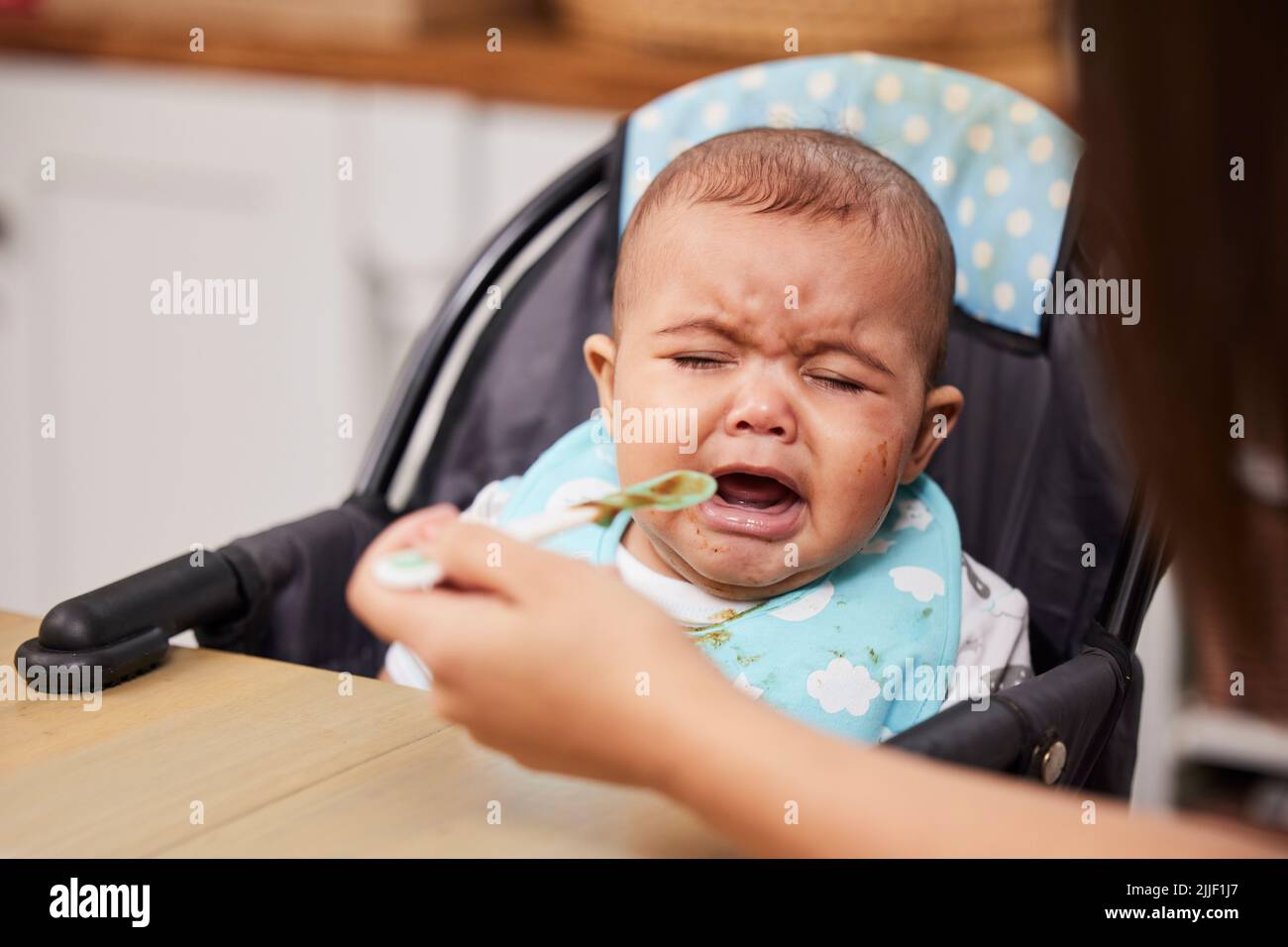 Ich bin hungrig, aber nicht dafür. Ein Baby weint, während es von seiner Mutter gefüttert wird. Stockfoto