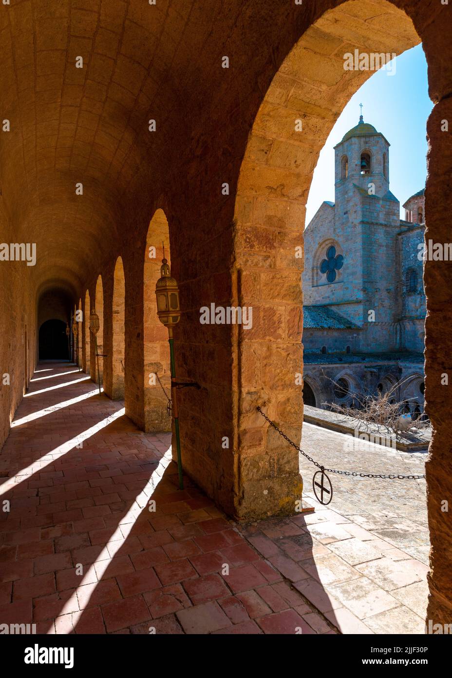Kirchturm der Abtei von Frontfroide, Frankreich, an einem sonnigen Winternachmittag ohne Menschen durch einen Bogen aufgenommen Stockfoto