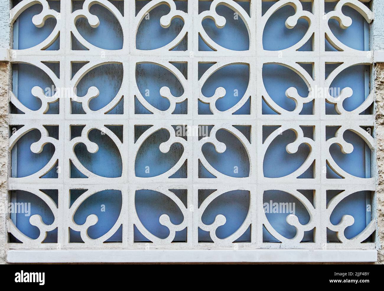 Textur aus geschmiedetem Metallgitter gegen blaues Fenster, Hintergrund Stockfoto