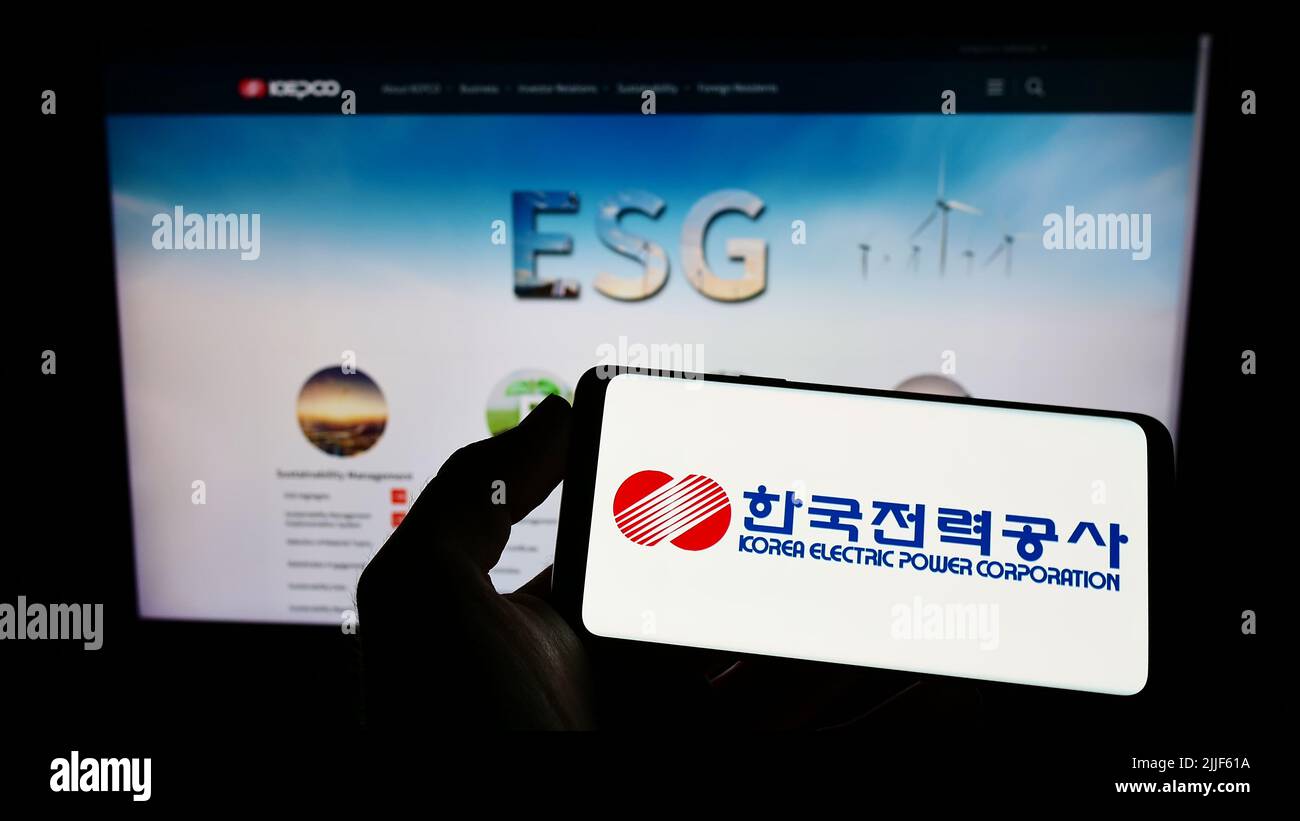 Person, die ein Mobiltelefon mit dem Logo der Korea Electric Power Corporation (KEPCO) auf dem Bildschirm vor der Business-Webseite hält. Konzentrieren Sie sich auf die Telefonanzeige. Stockfoto