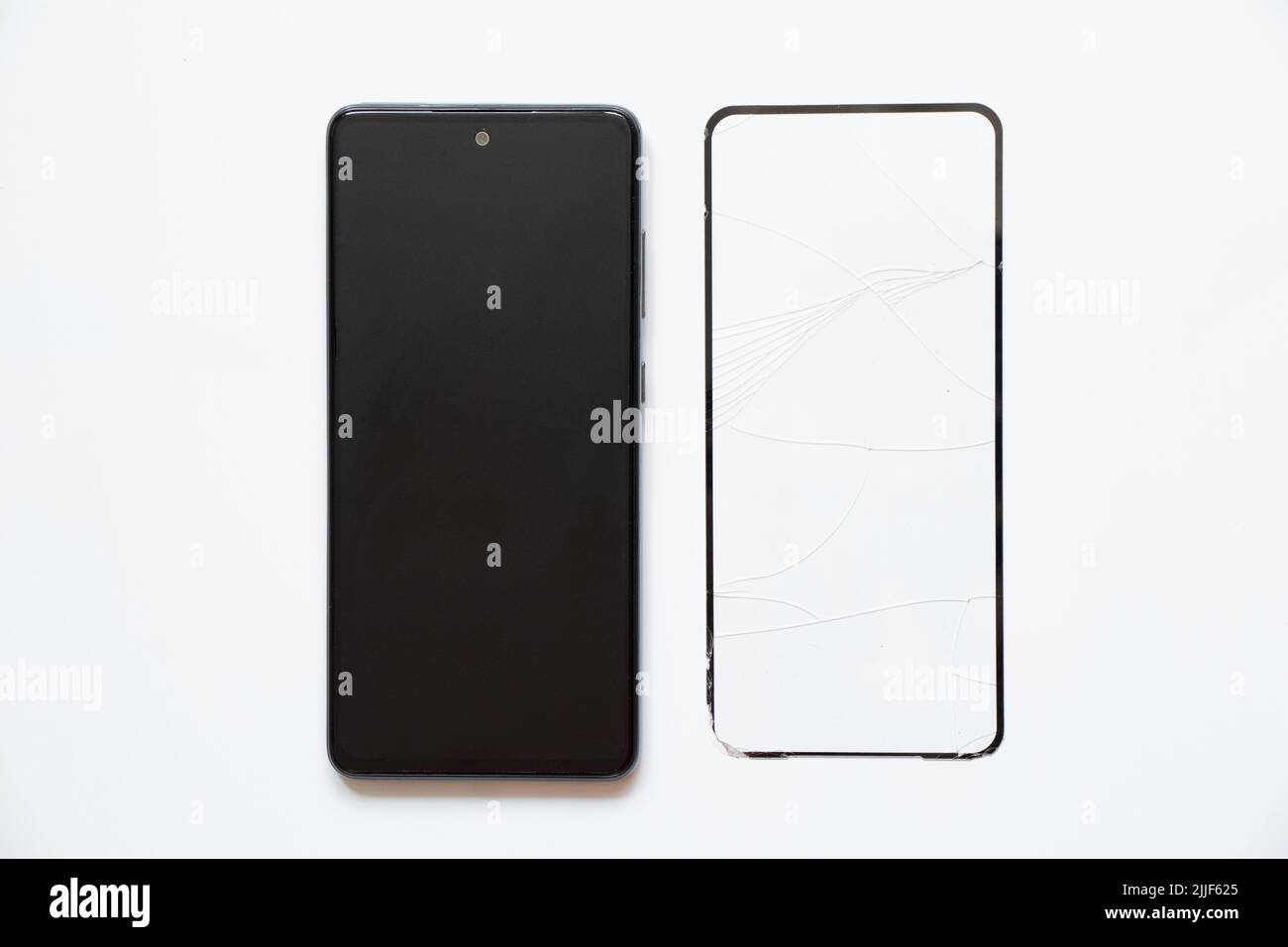 Telefon und gebrochenes Schutzglas liegen in der Nähe auf einem weißen Hintergrund, Austausch von Schutzglas auf einem Smartphone Stockfoto
