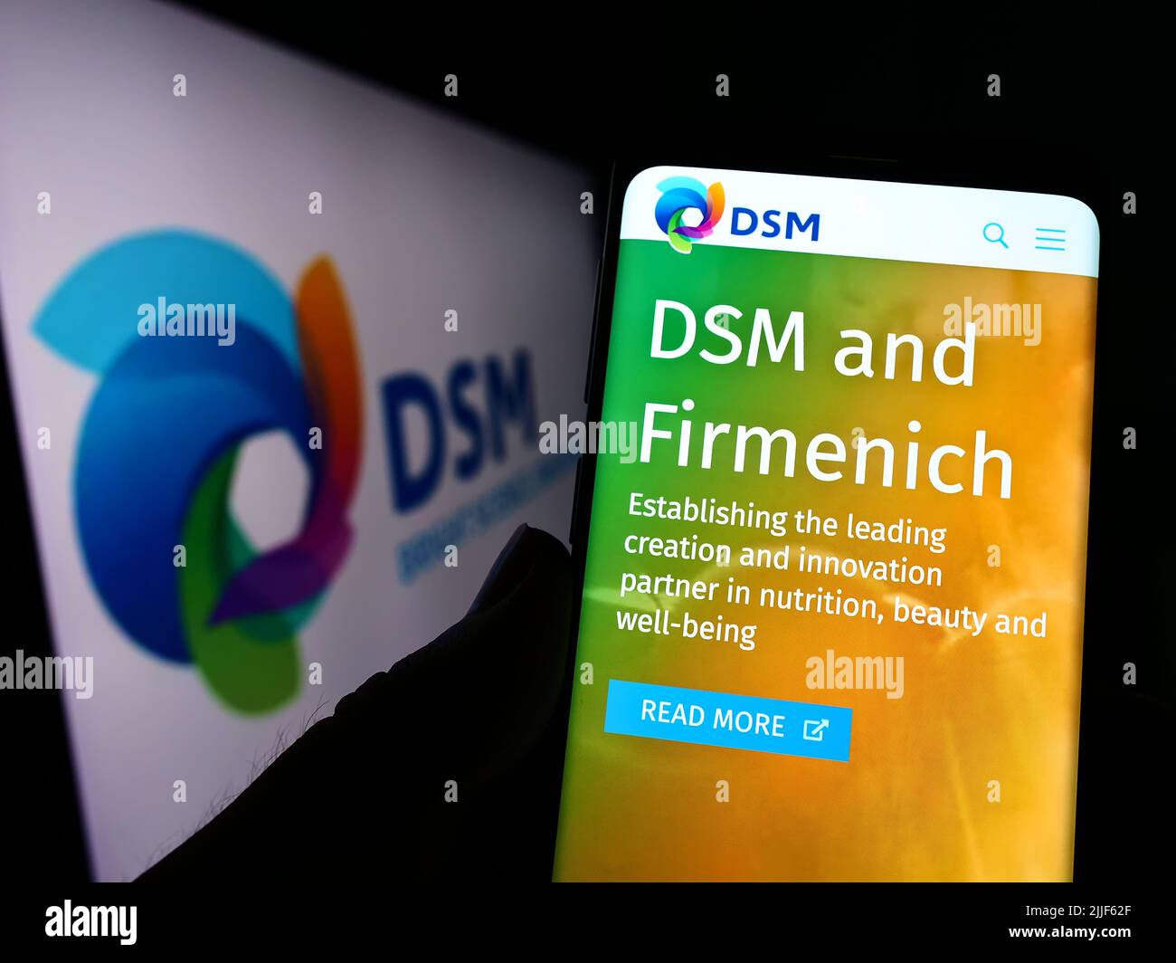 Person, die Mobiltelefon mit Website des niederländischen Chemieunternehmens Koninklijke DSM N.V. auf dem Bildschirm mit Logo hält. Konzentrieren Sie sich auf die Mitte des Telefondisplays. Stockfoto