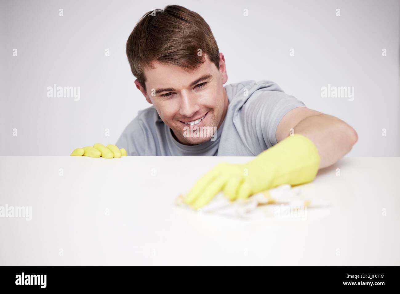 Ich habe fast einen Platz verpasst. Ein junger Mann, der zu Hause eine Theke putzt. Stockfoto