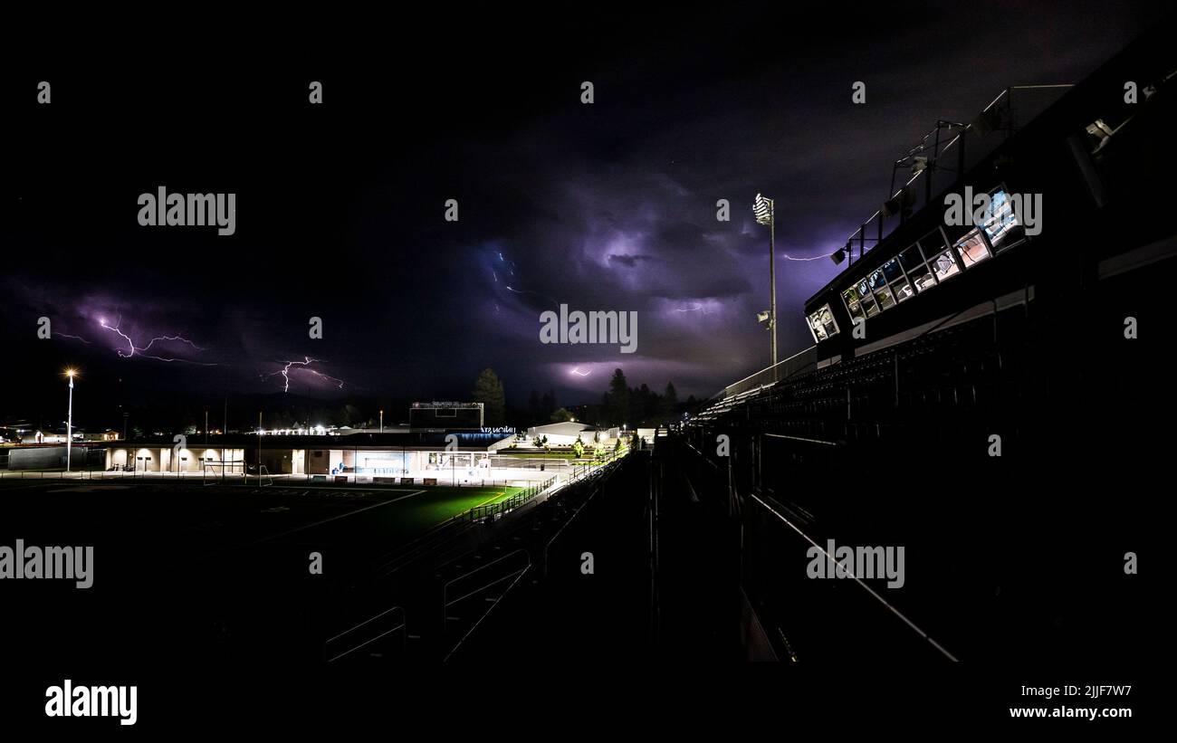 Über dem Union Stadium in Mead, Washington, erscheinen mehrere Blitzschläge in den Wolken, 17. Juli 2022. Neunzehn Luftwaffe und Zivilisten der 2. und 3. AVSs arbeiteten zusammen, um über zwei Wochen 22 Spiele für die Conseil International du Sport Militaire (International Council of Military Sports) World Women’s Football Championship live zu übertragen. Das Turnier brachte 10 Militärmannschaften aus der ganzen Welt, um Freundschaft durch Sport zu fördern, wie das CISM-Motto sagt. (USA Air Force Photo Composite von Samuel Morse) Stockfoto