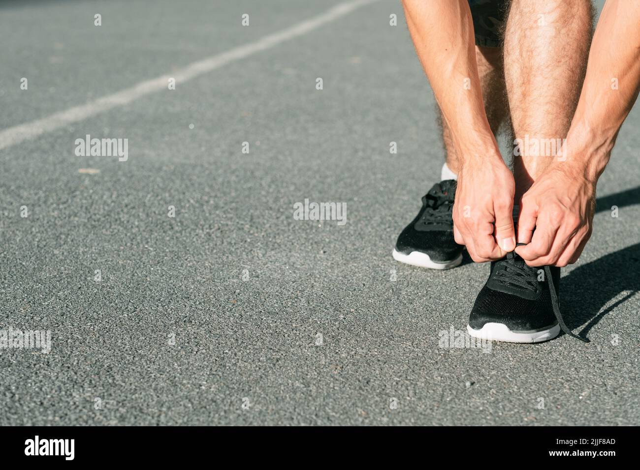 Läufer, die Schnürsenkel binden, führen Leichtathletik-Sport durch Stockfoto