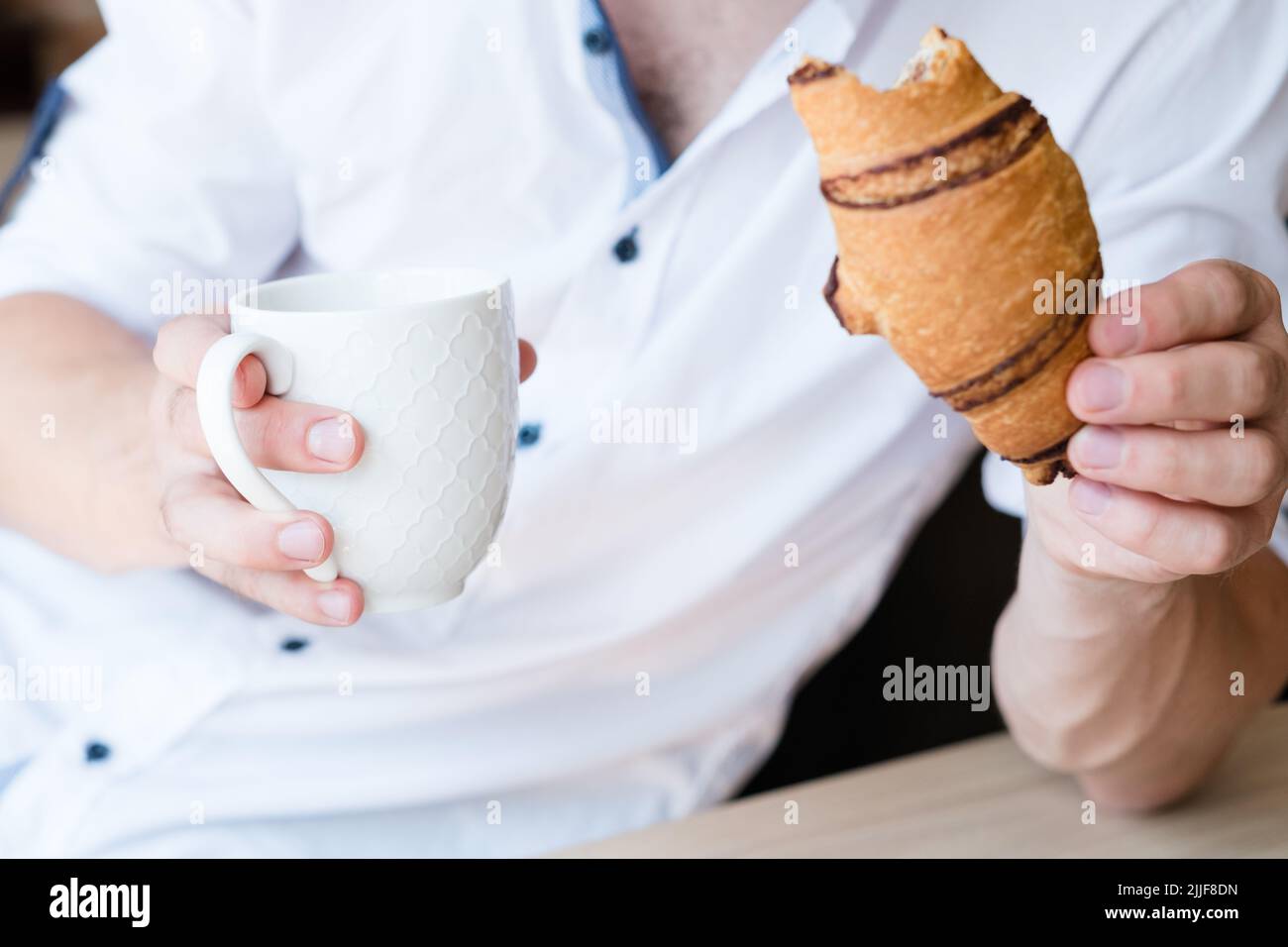 Snack Genuss Erfrischung Mann trinken Croissant Stockfoto