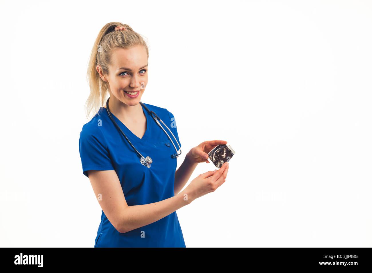 Eine lächelnde weiße Krankenschwester in Blau zeigt ein Foto eines Embryos - Nahaufnahme. Hochwertige Fotos Stockfoto