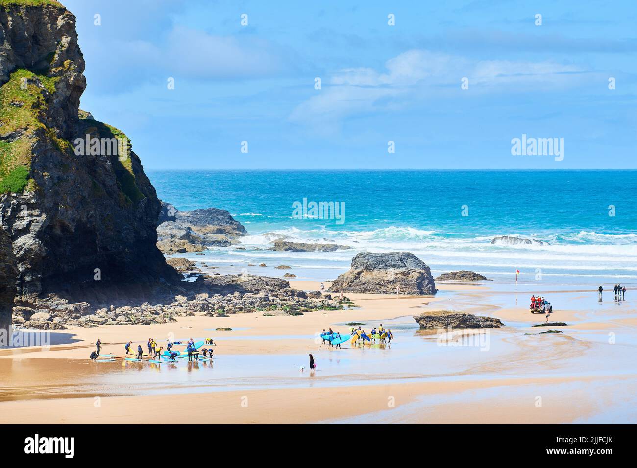 Am Strand von Mawgan Porth, Cornwall, England, schwängt eine Gruppe junger anfeigter Surfer. Stockfoto
