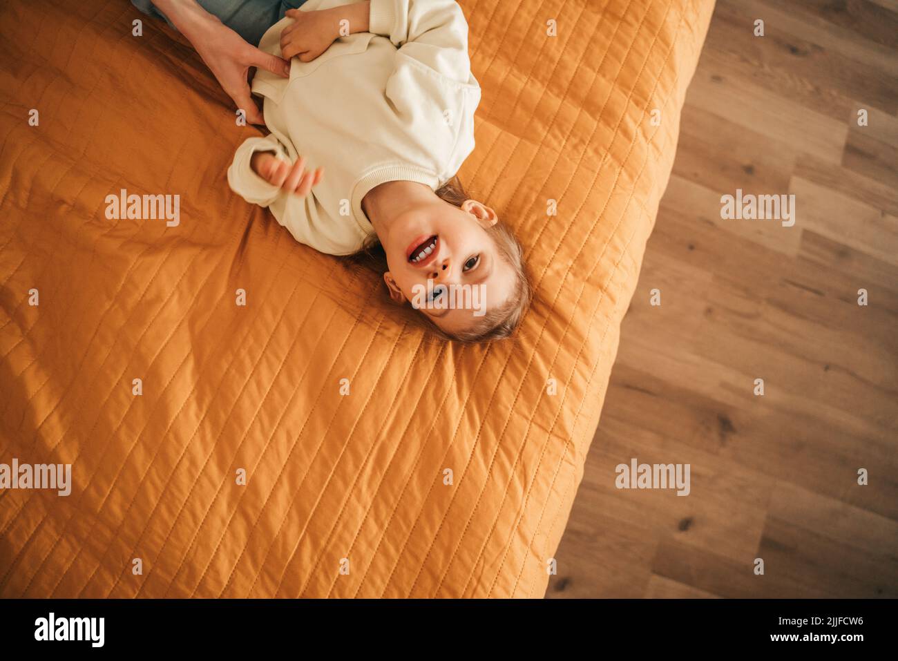 Kind wird von ihren Eltern ins Bett gelegt Stockfoto