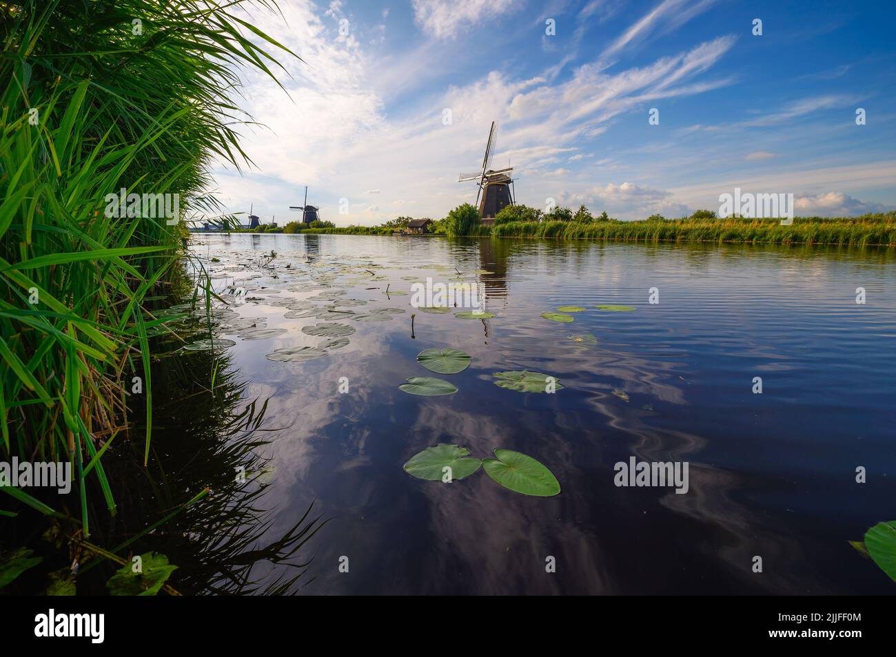 Historische Windmühlen und ein vorbeifließender Fluss in Kinderdijk, Niederlande Stockfoto