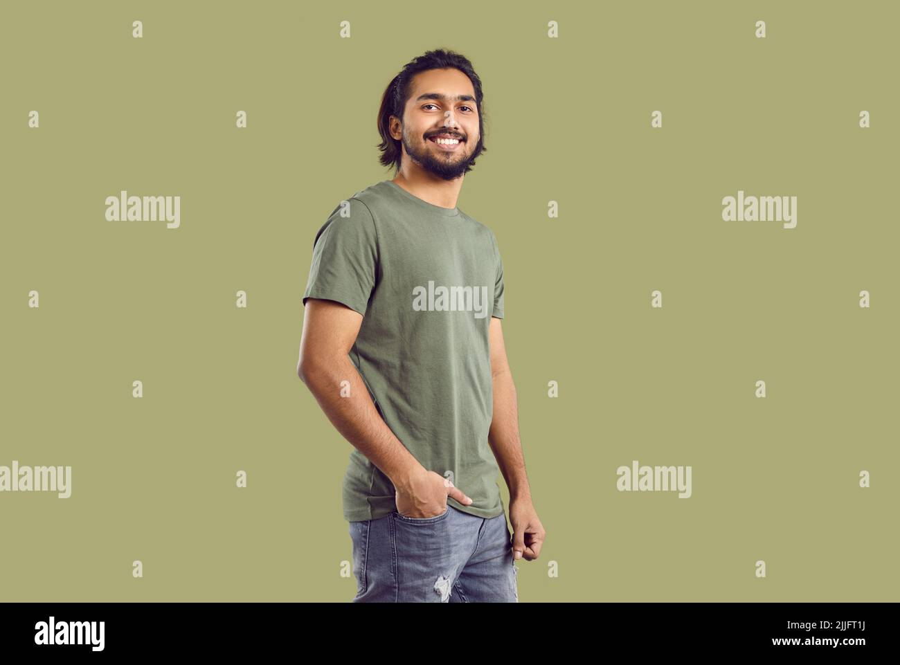 Porträt eines gutaussehenden selbstbewussten indischen Kerl trägt Freizeitkleidung auf khaki Hintergrund. Stockfoto
