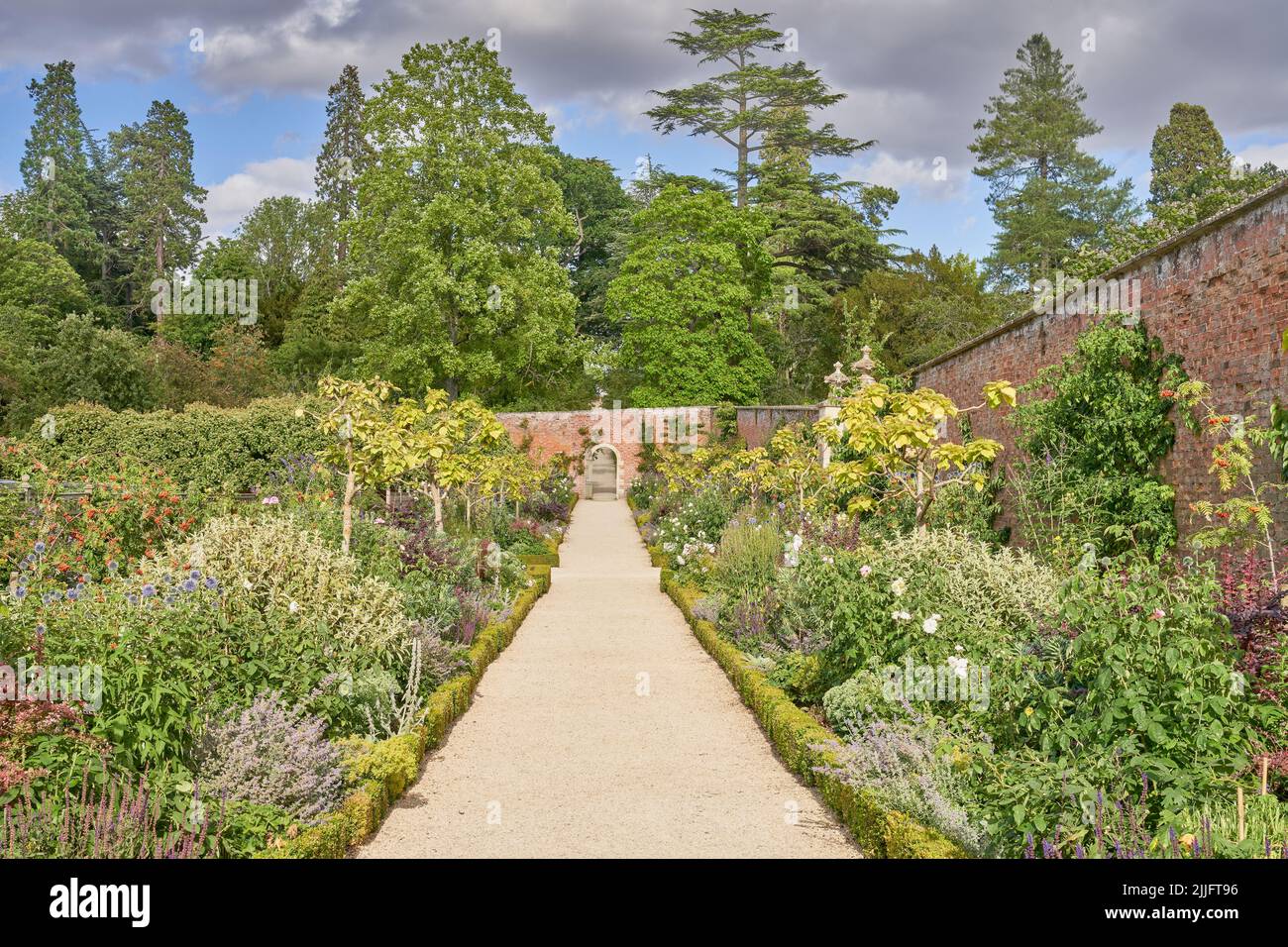 Ummauerter Garten mit Kiesweg und traditioneller krautiger