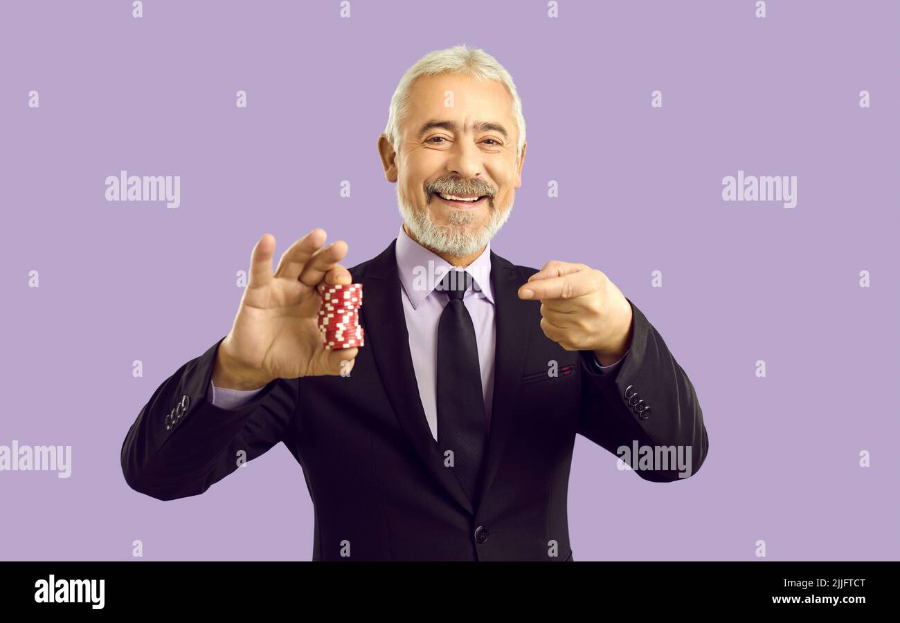 Lächelnder reifer Mann zeigen auf Casino-Chips Stockfoto