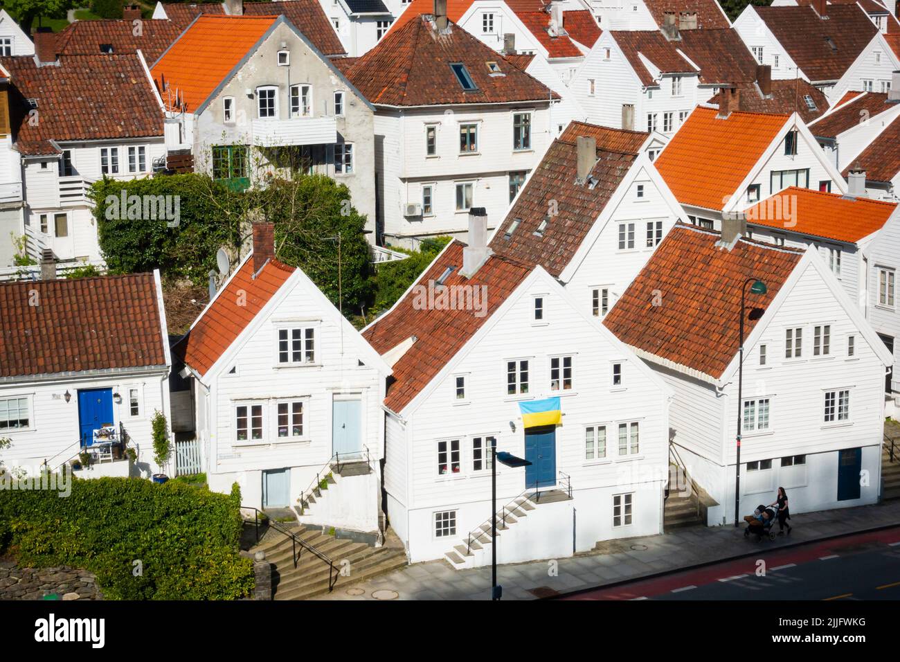 Traditionelle norwegische weiß bemalte Holzhäuser in Stavanger, Norwegen. Zur Unterstützung der Ukraine wird eine ukrainische Flagge geflogen Stockfoto