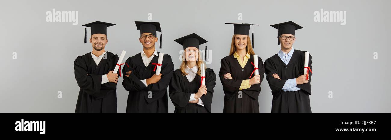 Glückliche, multiethnische College- oder Universitätsabsolventen, die ihre Diplome halten und lächeln Stockfoto