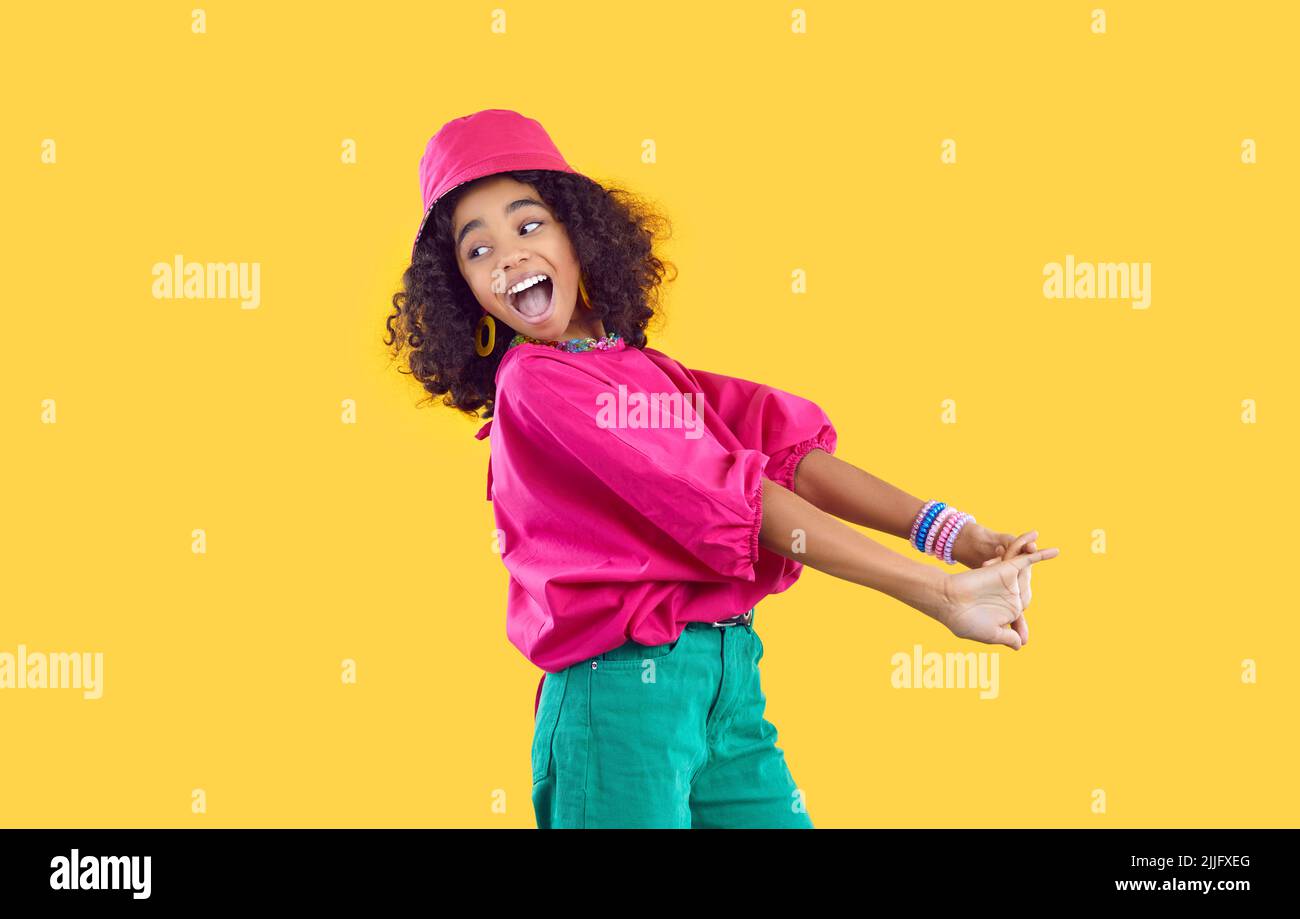 Fröhlich lustig stilvolle afroamerikanische Teenager-Mädchen mit Spaß auf lebhaft gelben Hintergrund. Stockfoto
