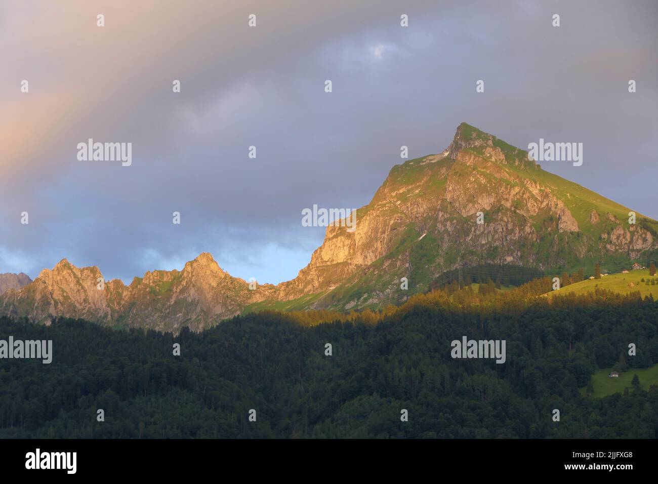 Ein majestätischer Berg namens Fronalpstock in den Glarner Alpen, der von der Abendsonne beleuchtet wird Stockfoto