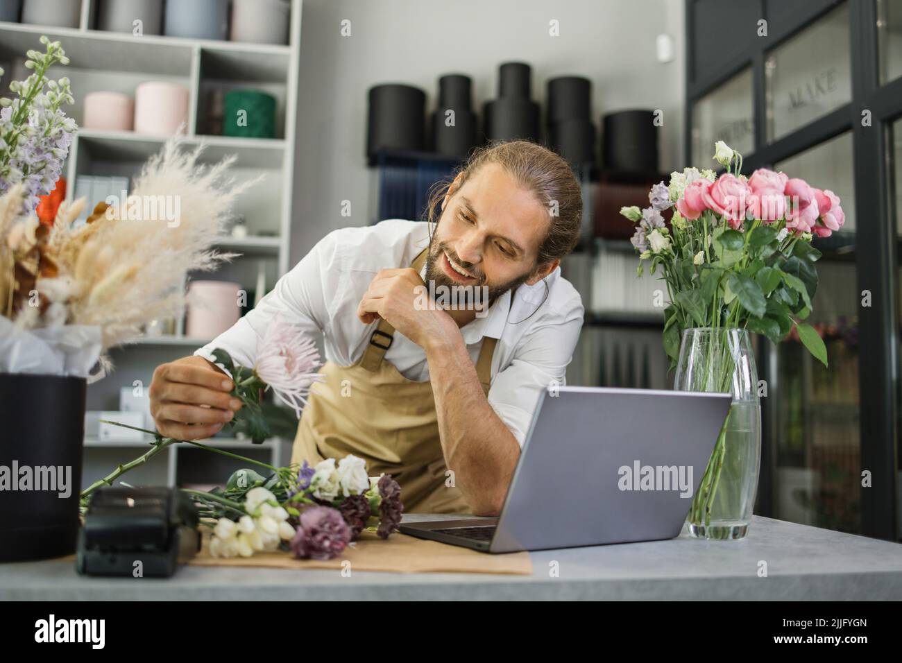 Floristin bärtiger Mann mit Laptop. GewächshausArbeiter, männlicher