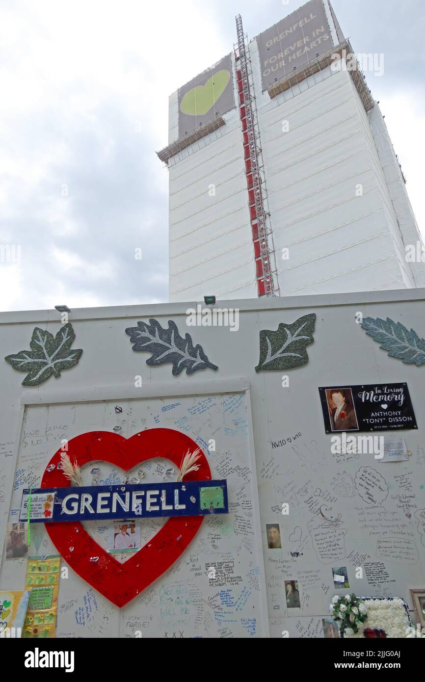 Grenfell Tower Feuertragödie Block, hinter der Gedenkmauer für die 72 Opfer gezeigt. Grenfell United, für immer, nach dem Beschuss der Verkleidung im Jahr 2017 Stockfoto