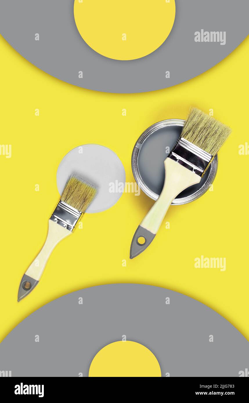 Vertikales Foto mit Farbkisten mit Pinsel auf gelbem und grauem Hintergrund mit Papierkreis. Stockfoto