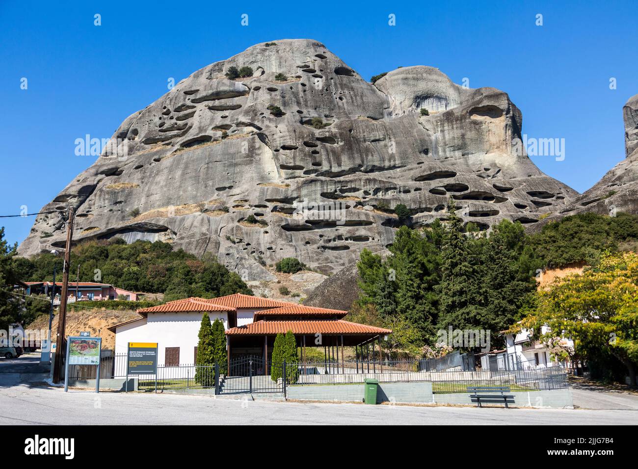 Die natürlichen Höhlen für Mönche in den Felsformationen von Meteora über den Häusern von Kastraki, Kalabaka, Griechenland Stockfoto