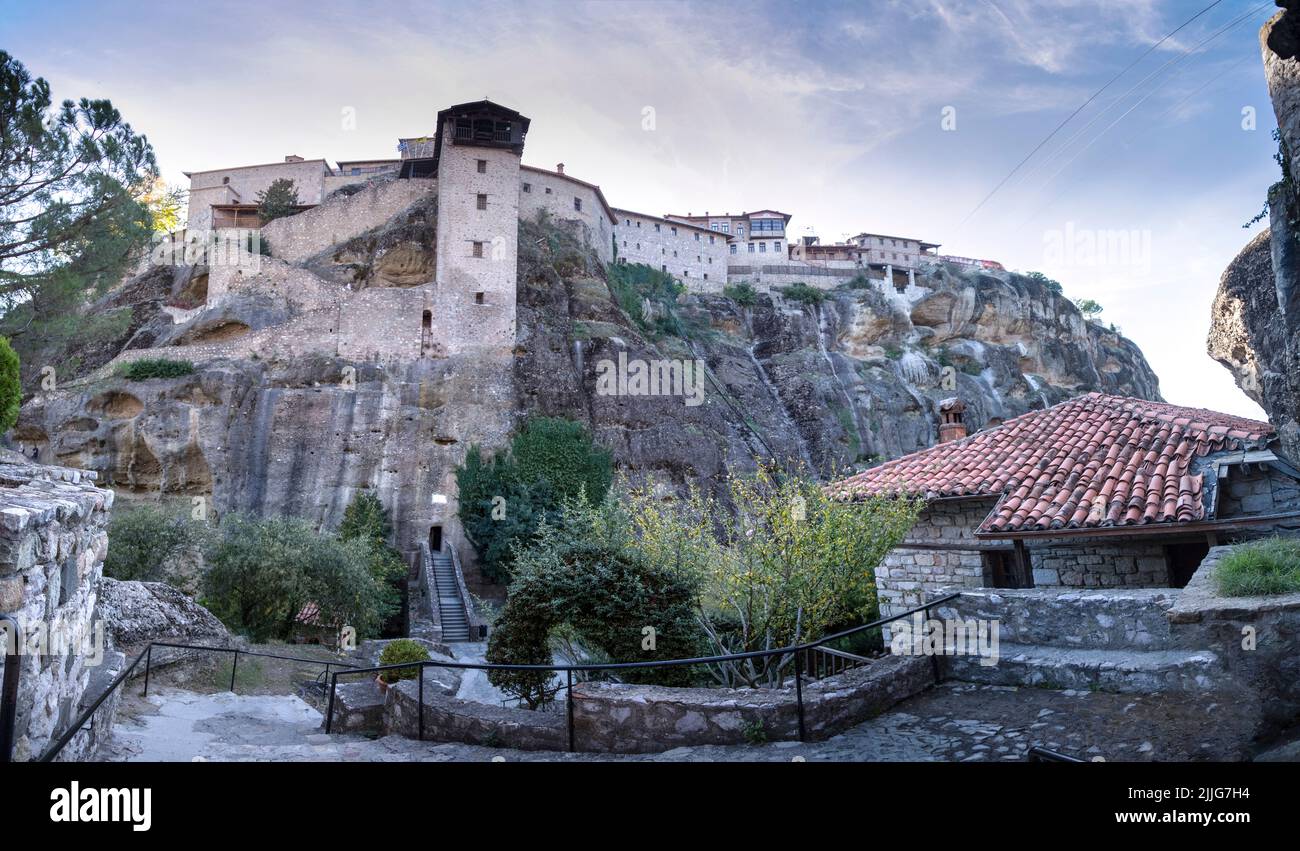 Schöner Panoramablick auf die orthodoxen Klöster von Great Meteor, immense monolithische Säule, grünes Laub im Hintergrund der Steinmauer in Meteo Stockfoto
