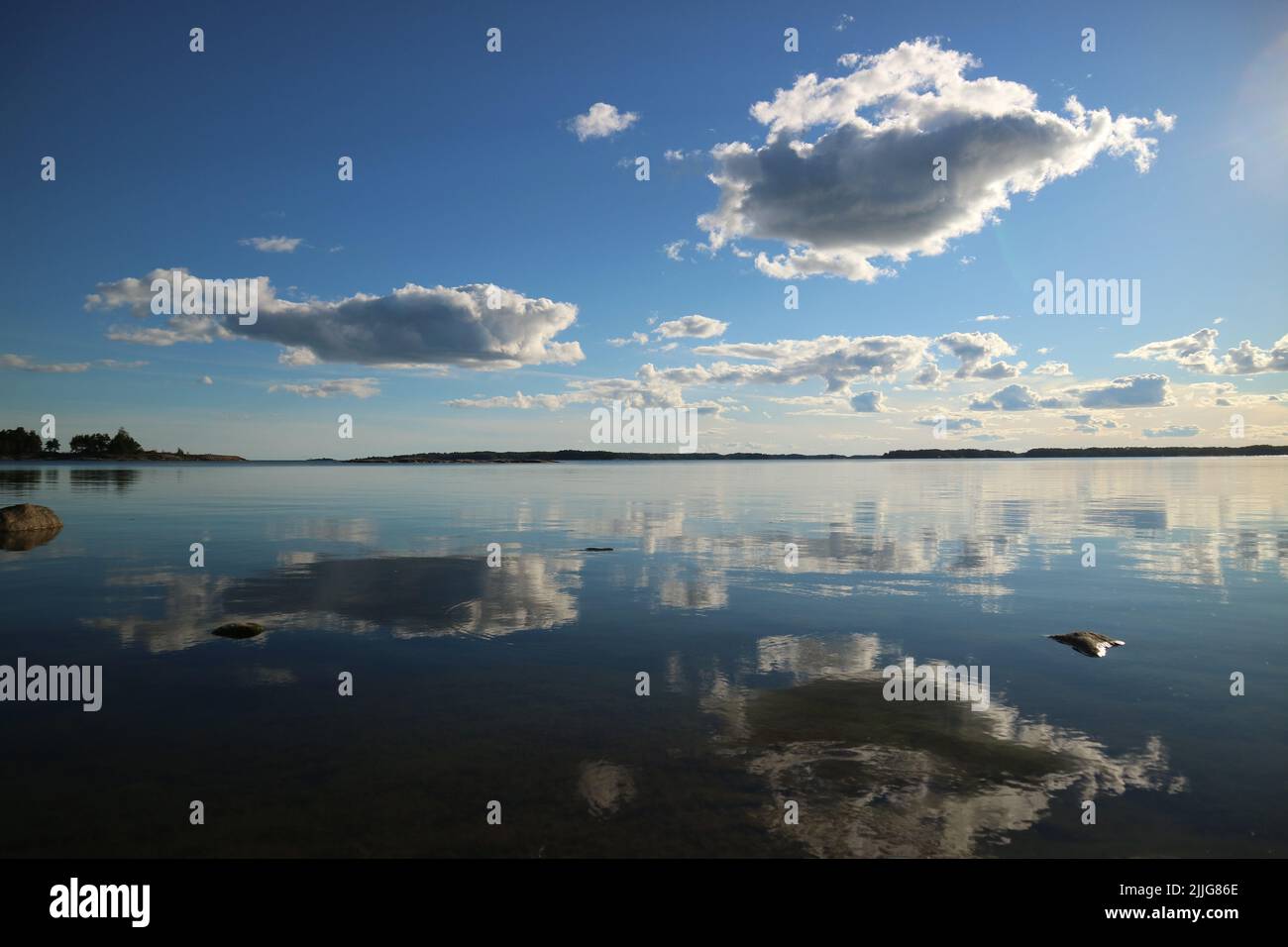 Auf dem stillen Wasser von Degeröfjärden in Inkoo, Finnland, ziehen sich Wolken zurück. Stockfoto