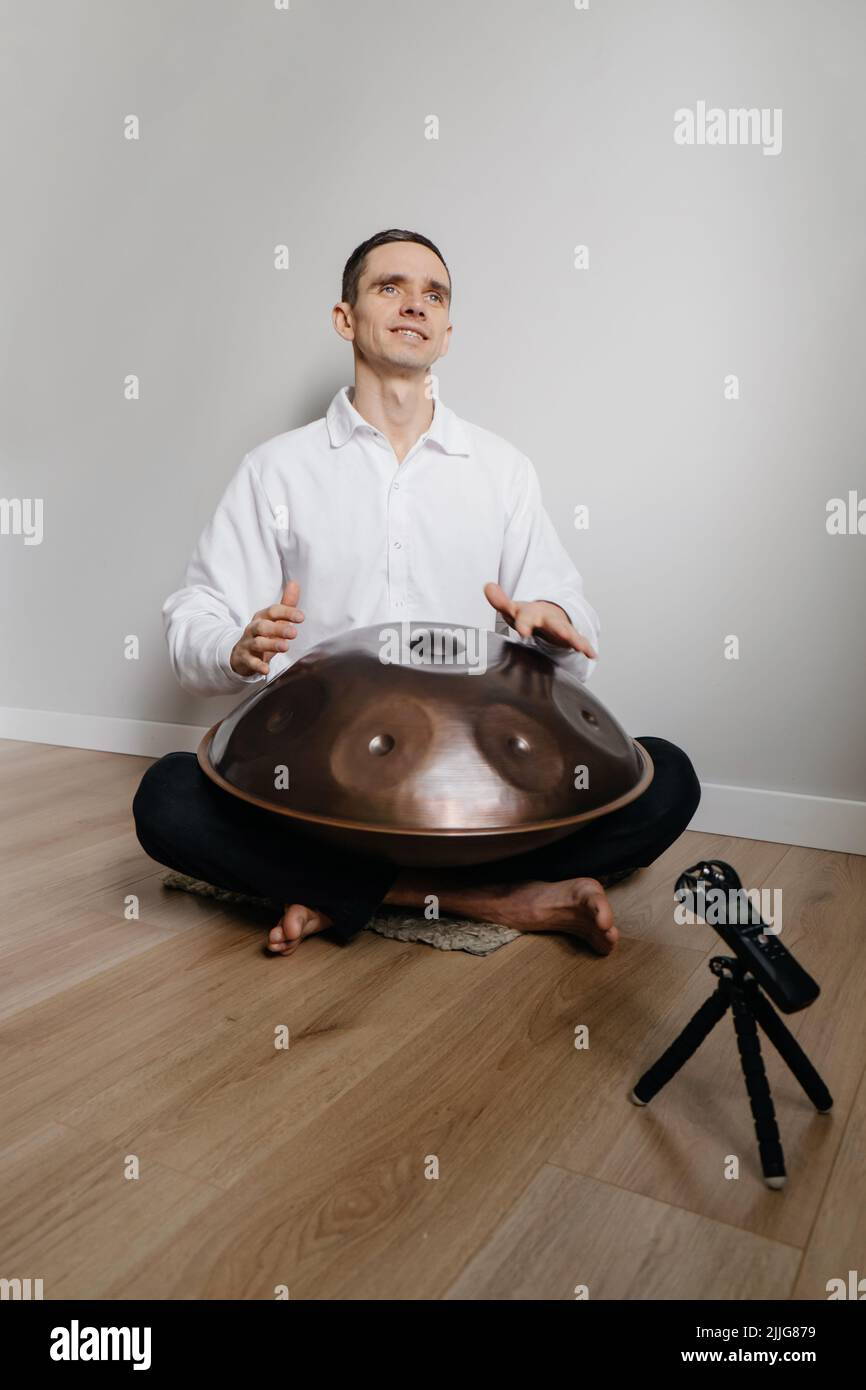 Mann, der auf der Hangdrum oder Steel Drum, Hangpan, einem modernen  Musikinstrument aus Stahl zu Hause, spielt. Tonaufnahme für  Meditationsmusik zum Entspannen Stockfotografie - Alamy
